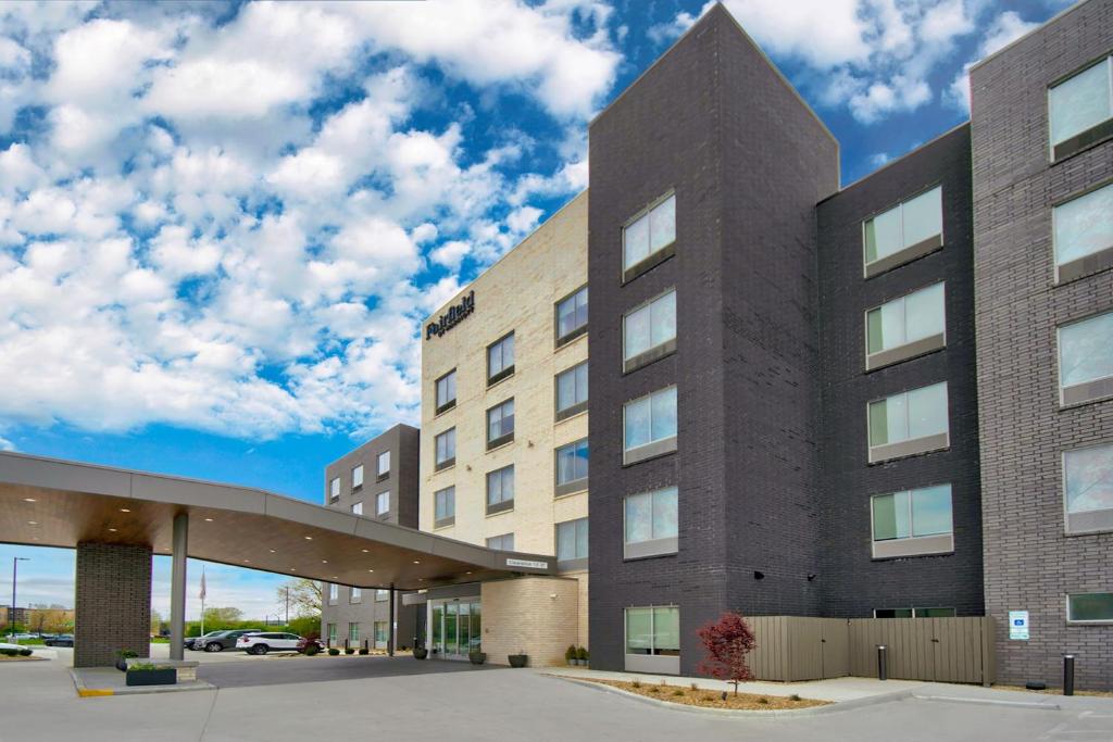 西切斯特Fairfield by Marriott Inn & Suites Cincinnati North West Chester的云天的停车场内的建筑物
