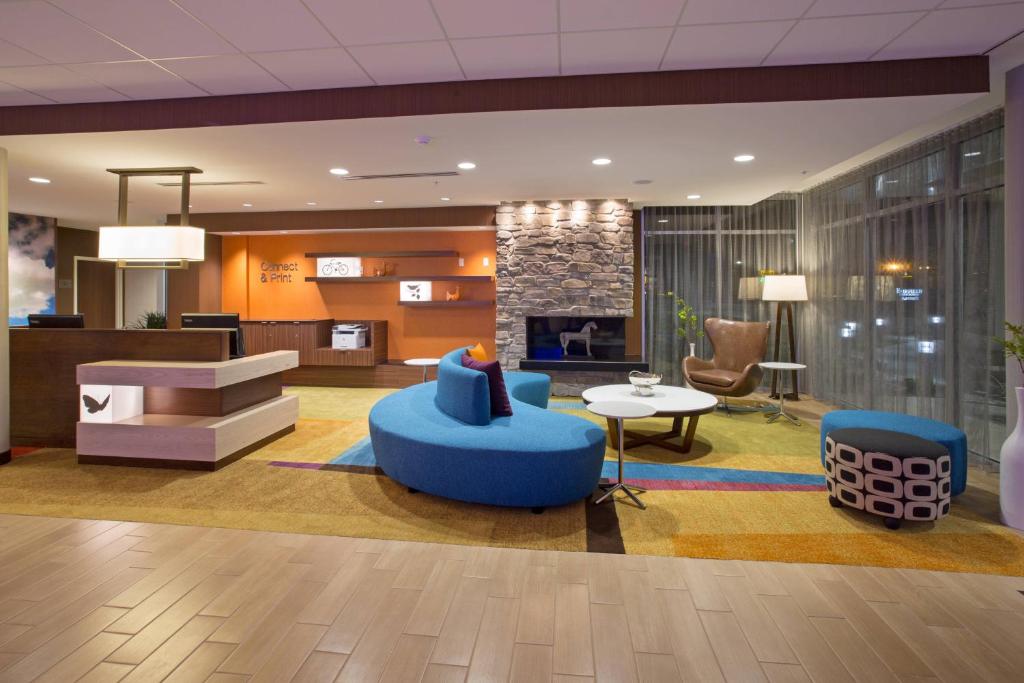 伯灵顿Fairfield Inn & Suites by Marriott Burlington的大堂设有蓝色椅子和壁炉