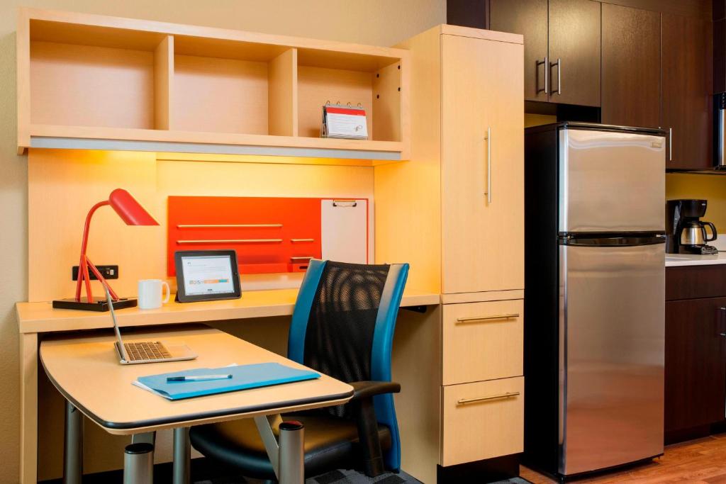 雷德迪尔莱德迪尔万豪广场套房酒店的厨房配有带笔记本电脑和冰箱的书桌