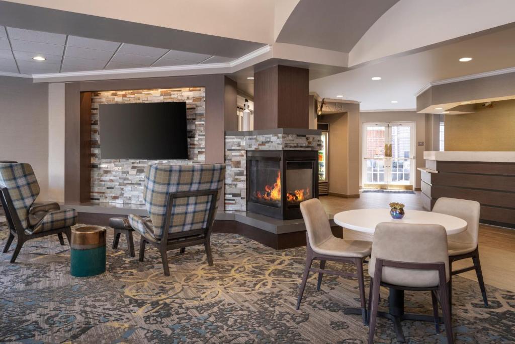 盐湖城盐湖城机场Residence Inn酒店的大堂设有壁炉和桌椅。