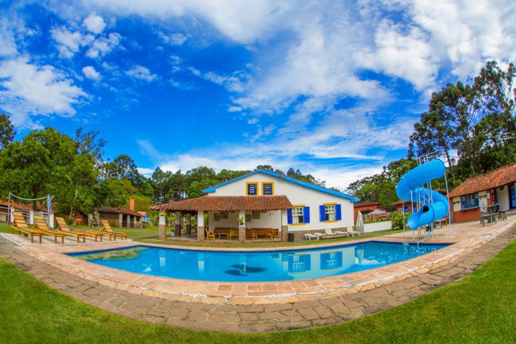 阿蒂巴亚Pousada Águas do Vale的房屋前的大型游泳池