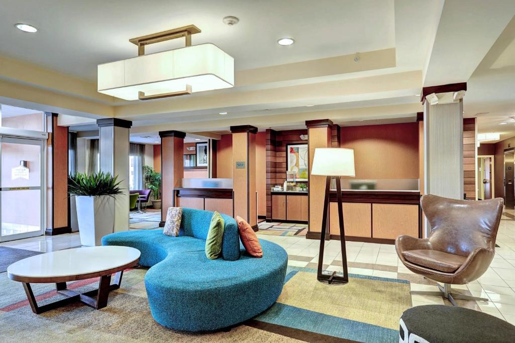 爱迪生南普兰菲尔德豪费尔菲尔德埃蒂森套房酒店的客厅配有蓝色的沙发和椅子