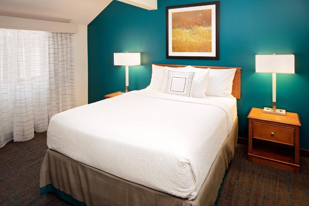 哈里斯堡哈里斯堡赫氏住宿酒店的卧室配有一张白色大床和蓝色的墙壁