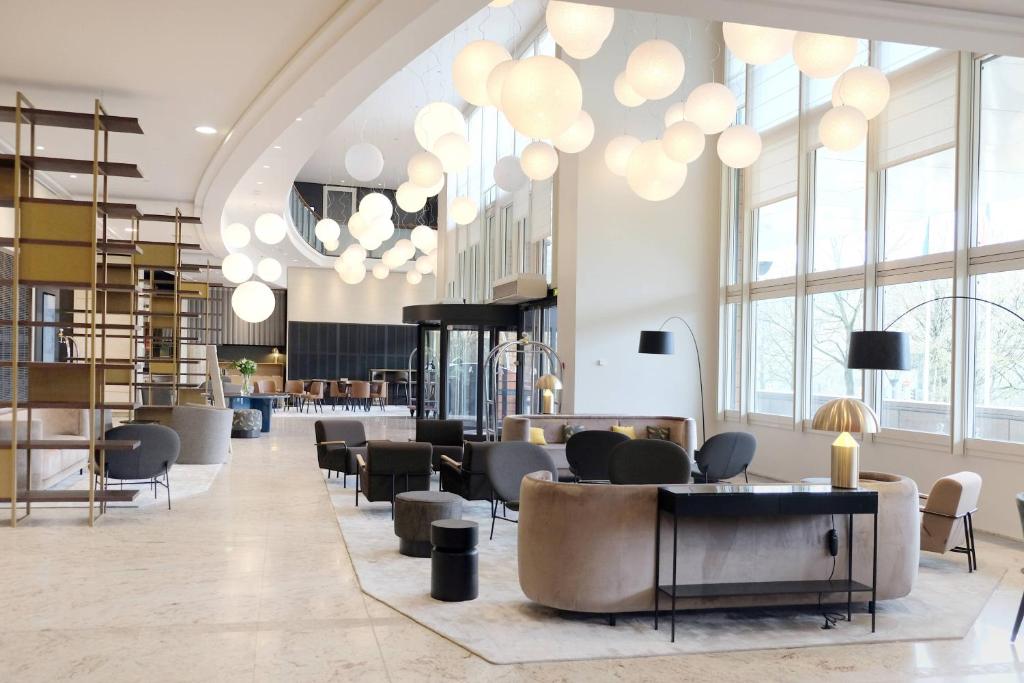 里昂里昂塞特万豪国际酒店的大堂设有桌椅和大窗户。