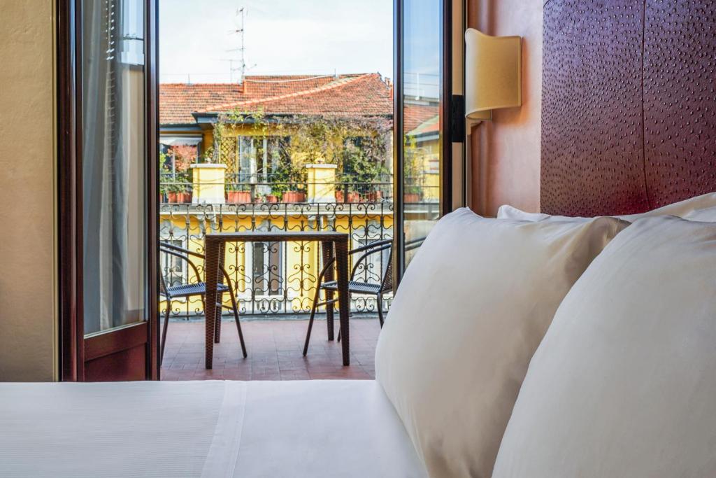 米兰帕妮萨酒店的一间卧室设有一张床,享有阳台的景色