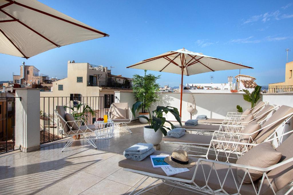 马略卡岛帕尔马Samaritana Suites的屋顶上带椅子和遮阳伞的天井