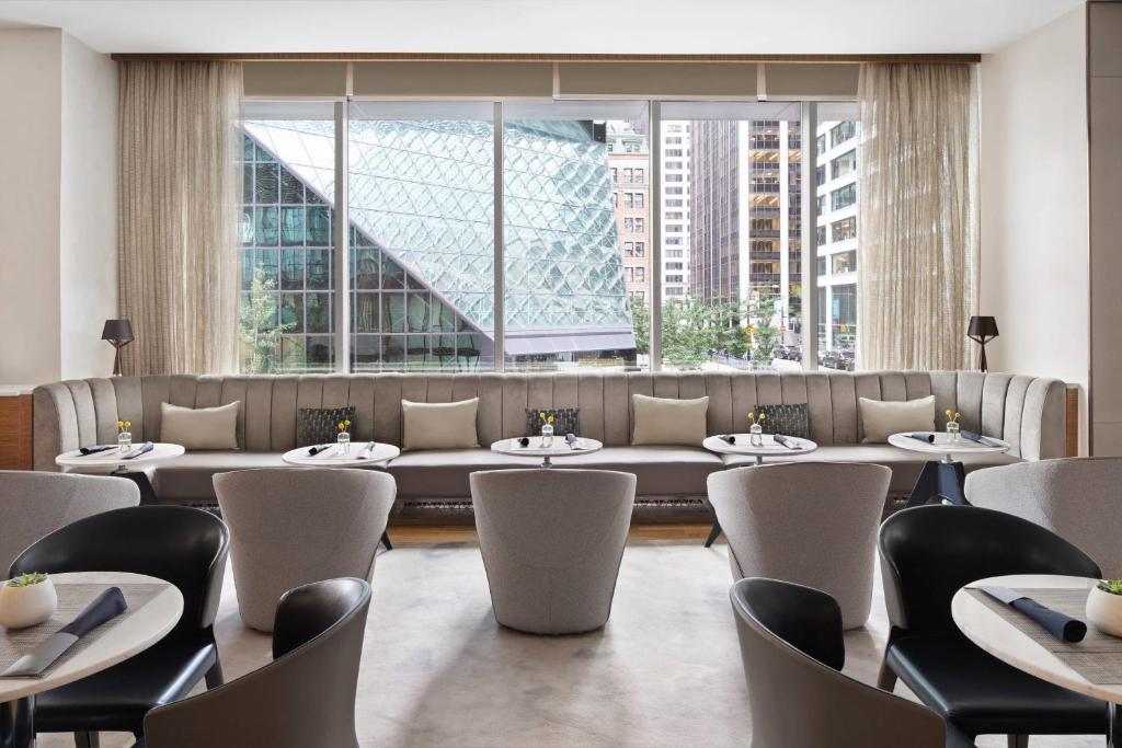 纽约AC Hotel by Marriott New York Downtown的餐厅设有桌椅和大窗户。