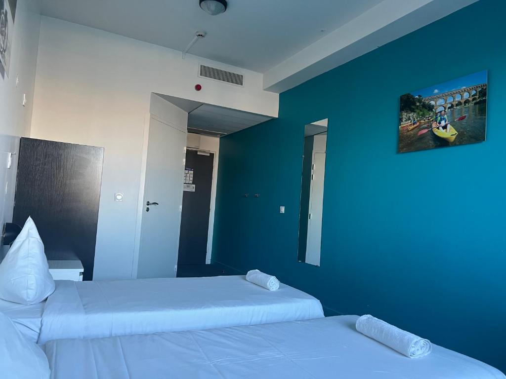 巴黎国际雷斯当斯酒店的蓝色墙壁客房的两张床