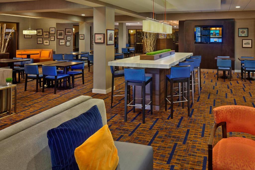 基韦斯特基韦斯特海滨万豪万怡酒店的餐厅设有酒吧,配有蓝色的桌椅