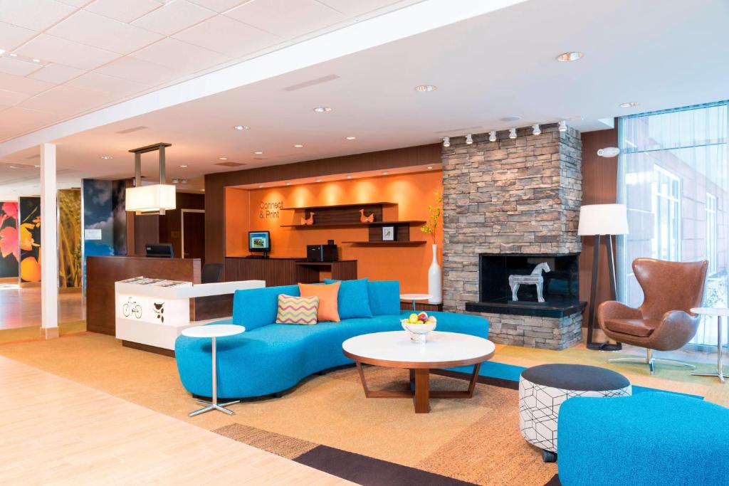 费舍尔Fairfield Inn & Suites by Marriott Indianapolis Fishers的客厅设有蓝色的沙发和壁炉