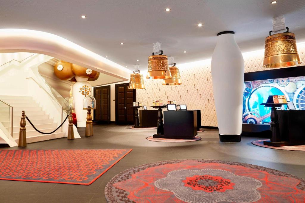 格拉特布鲁格苏黎世波恩卡梅哈格兰德签名收藏酒店的大堂设有红色地毯和大型白色花瓶的房间