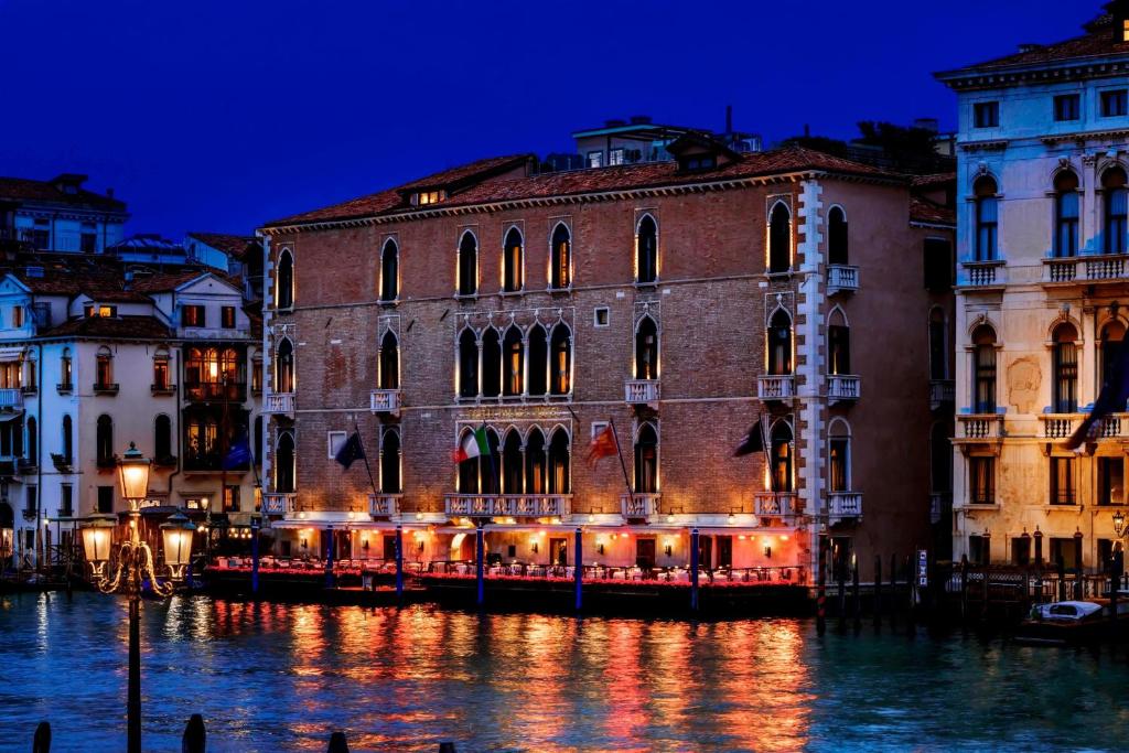 威尼斯The Gritti Palace, a Luxury Collection Hotel, Venice的一群晚上在水面上的建筑