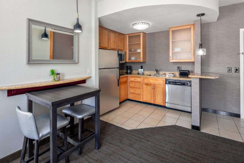 瑟普赖斯西北凤凰城/瑟普莱斯原住客栈的厨房配有桌子和冰箱