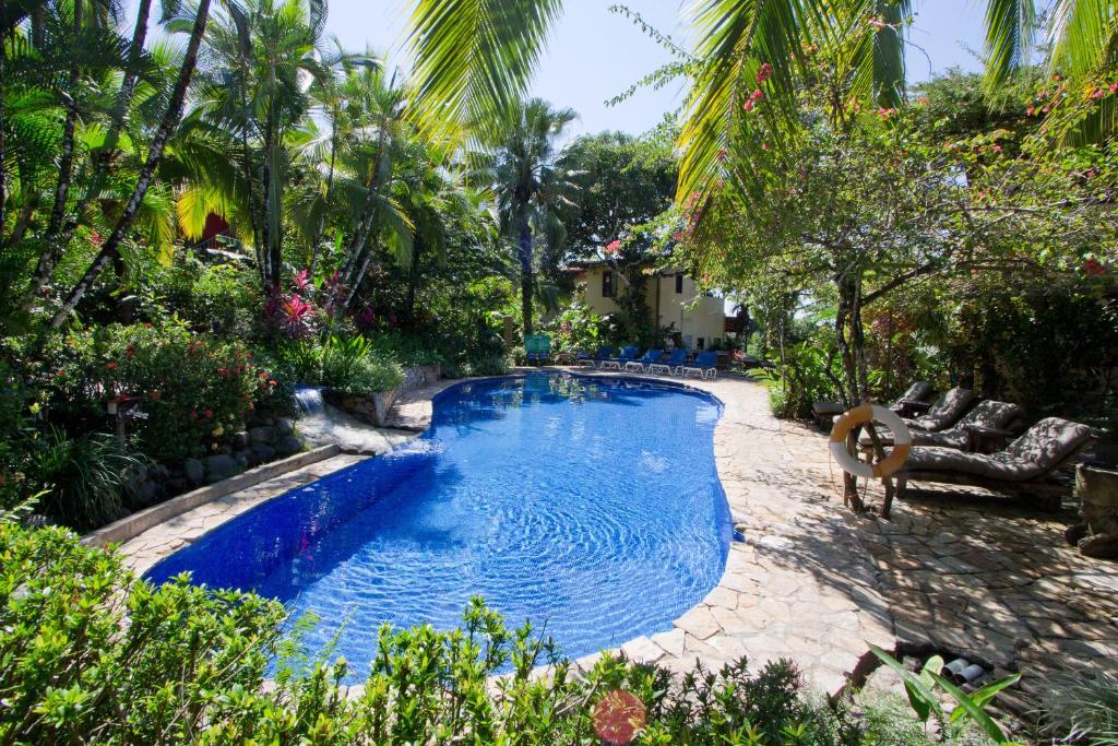 曼努埃尔安东尼奥Hotel Villas Nicolas - Adults Only的棕榈树庭院内的游泳池