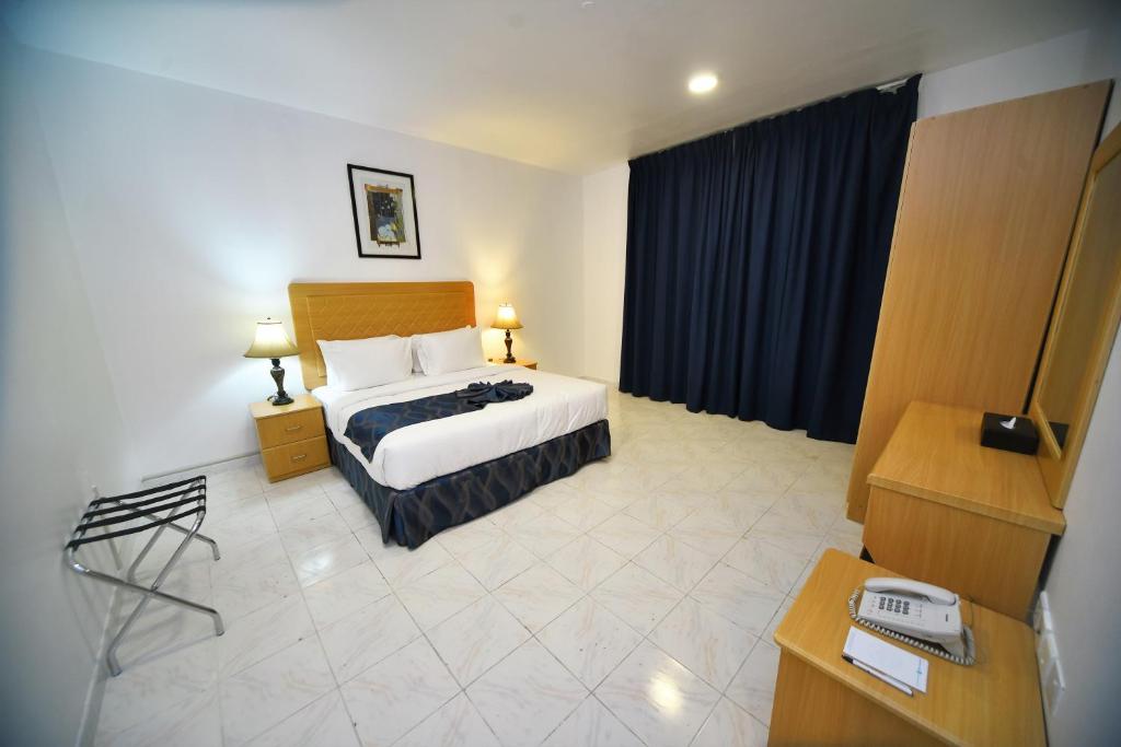 阿吉曼Alain Hotel Apartments Ajman的配有一张床和一张书桌的酒店客房