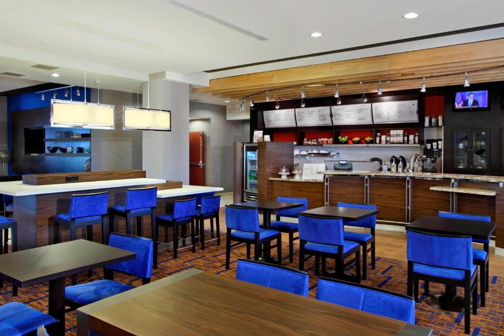 维多利亚维多利亚万怡酒店的一间设有蓝色桌椅的餐厅和一间酒吧