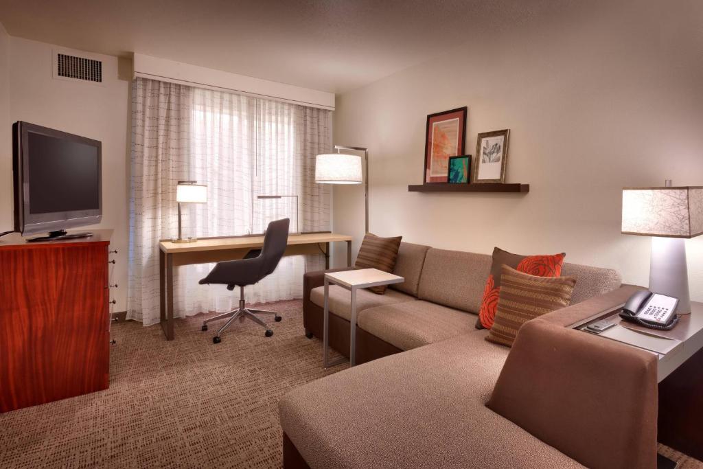桑迪盐湖城桑迪公寓的一间客厅,客厅配有沙发和一张书桌,位于酒店的房间