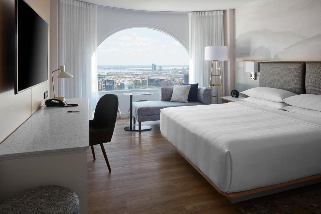 蒙特利尔尚普兰蒙特利尔万豪酒店的酒店的客房 - 带一张床、椅子和窗户