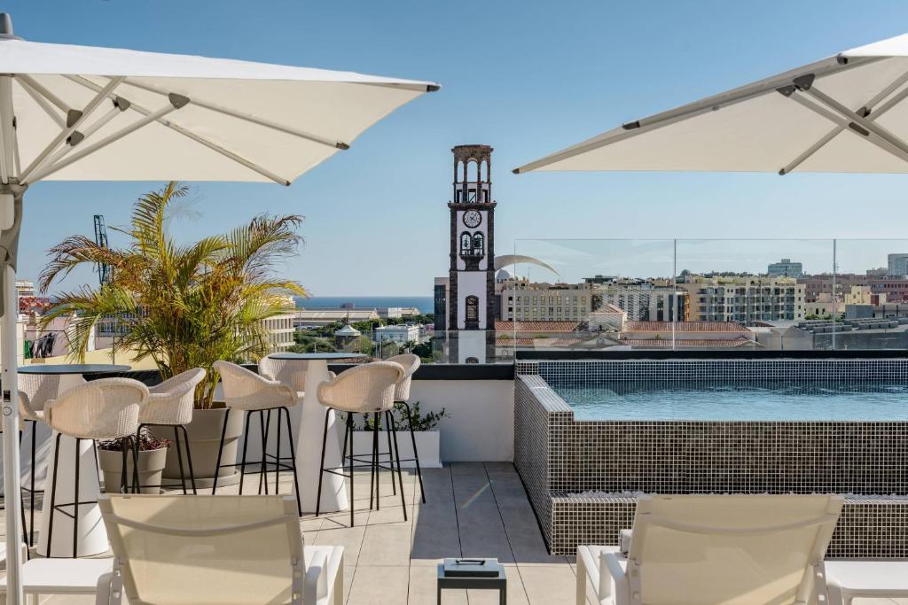 圣克鲁斯-德特内里费AC Hotel by Marriott Tenerife的屋顶酒吧设有椅子和游泳池