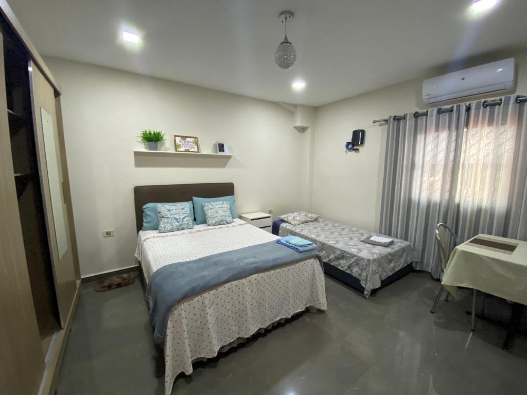 埃斯特城Agradable dormitorio en suite con estacionamiento privado的一间医院间,配有两张床和一张桌子