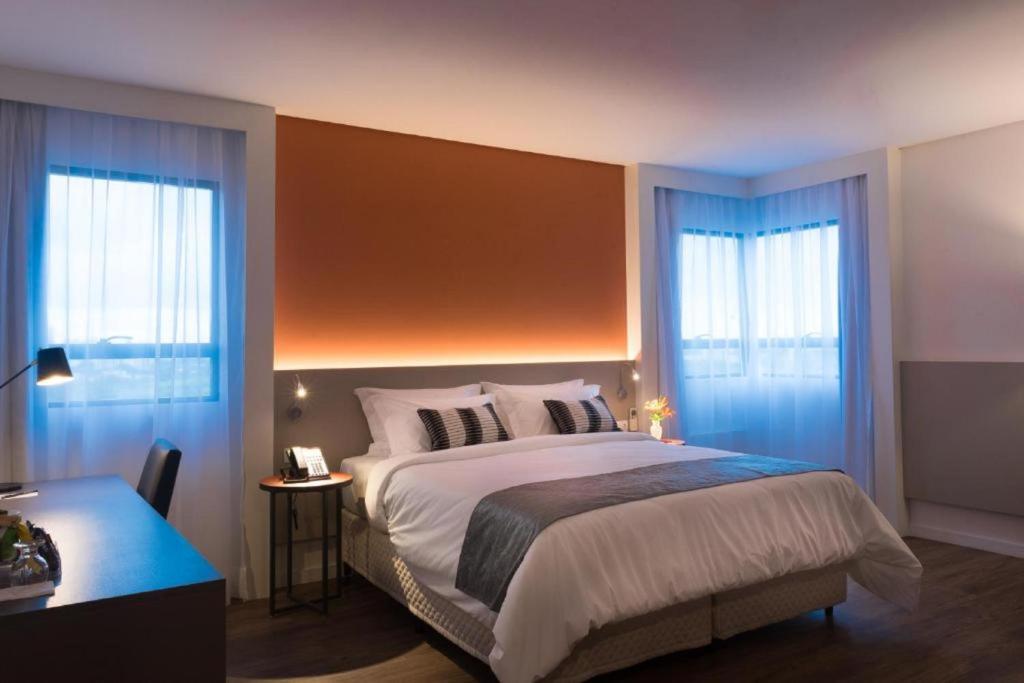 圣保罗Intercity São Paulo Anhembi的一间卧室设有一张大床和两个窗户。