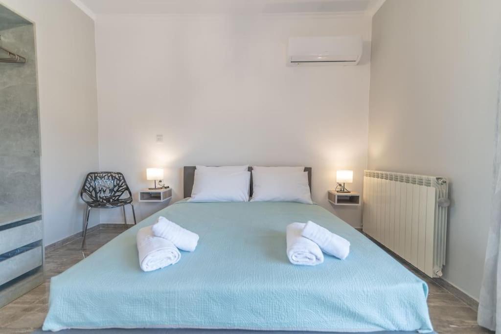 帕萨里迪Kos Helios House的一间卧室配有蓝色的床和两个枕头