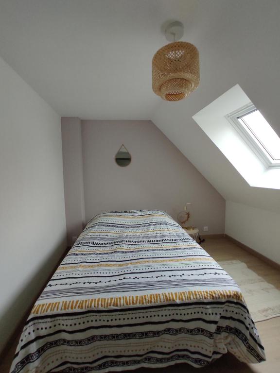 沙托鲁La Petite Chaume的一间卧室配有一张床铺,床上有毯子