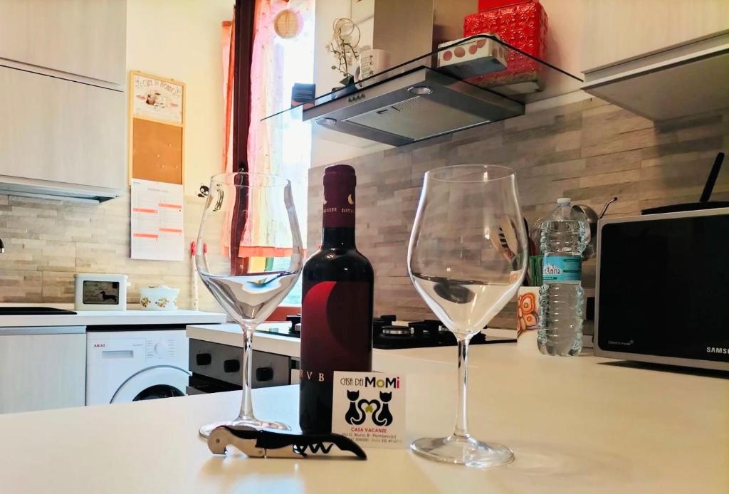 皮昂比诺Casa dei MoMi的柜台上的一瓶葡萄酒和两杯酒杯