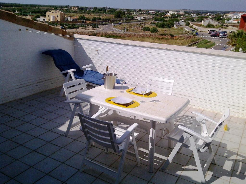 休达德亚Apart duplex Cala Busquets的屋顶上的白色桌子和椅子