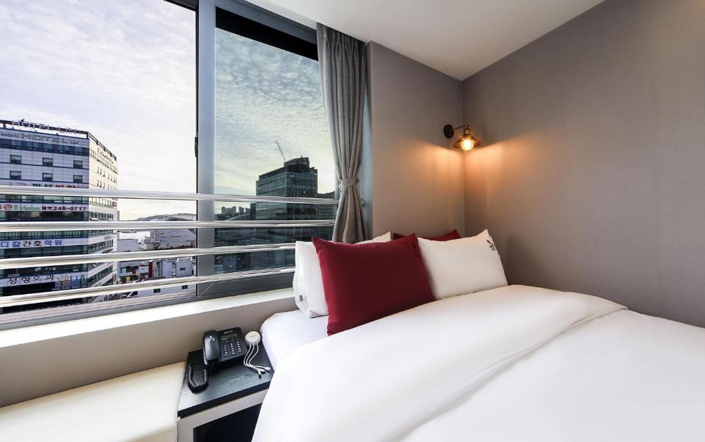 釜山Maron Hotel Nampo的酒店客房设有一张床和一个大窗户