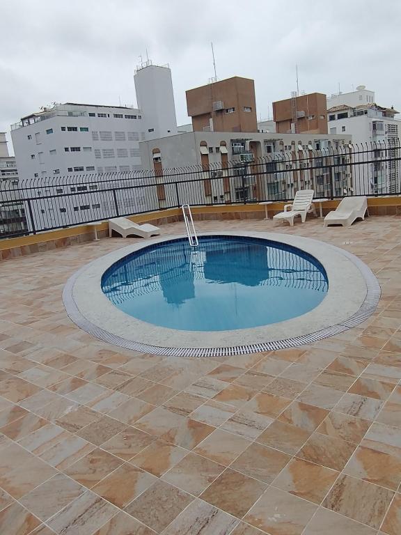 瓜鲁雅Praia de Pitangueiras, flat, do lado da praia sem roupas de cama的建筑物屋顶上的游泳池