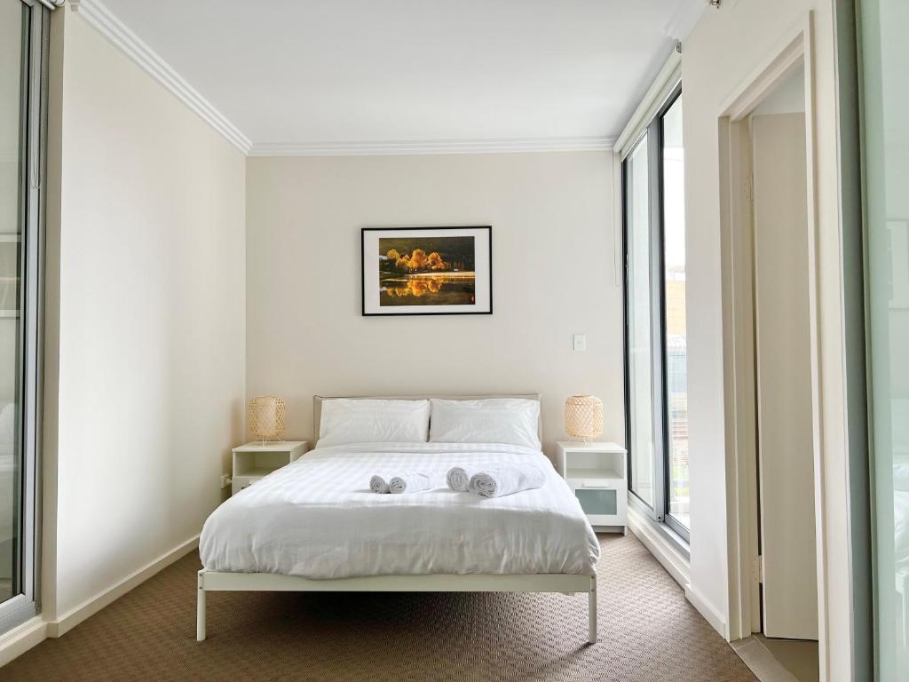悉尼Charming One-Bed Apt in the Heart of Parramatta的一间卧室配有一张床,上面有两条毛巾