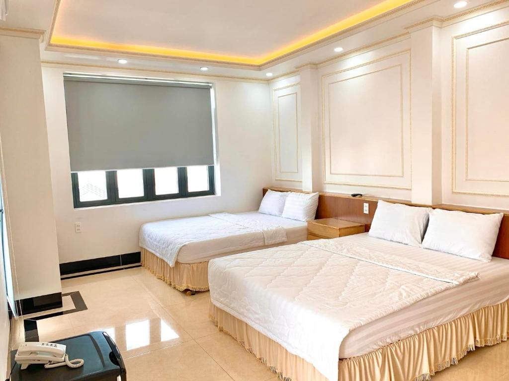 Bạc LiêuPhụng Hoàng Vũ的酒店客房设有两张床和窗户。