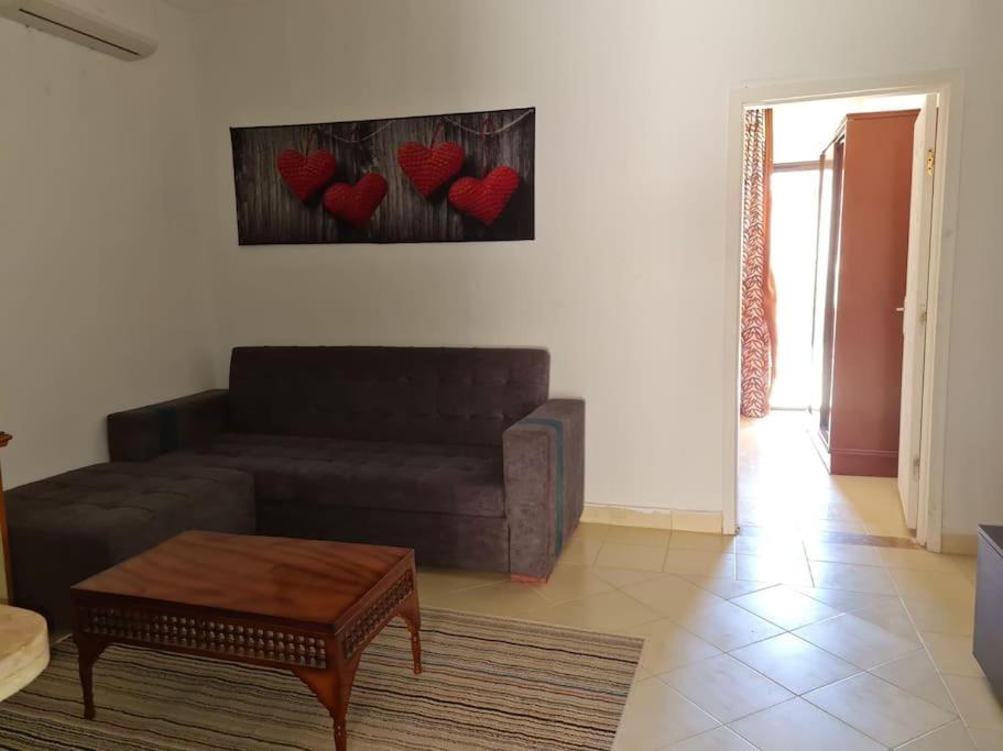沙姆沙伊赫basic 2 bedroom apartment的客厅配有沙发,墙上挂着心。
