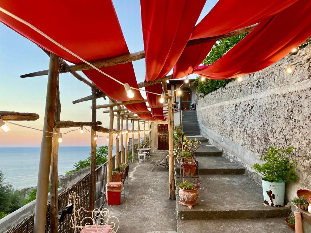 阿马尔菲Casa San Pietro的一个带红色遮阳伞和海洋的庭院