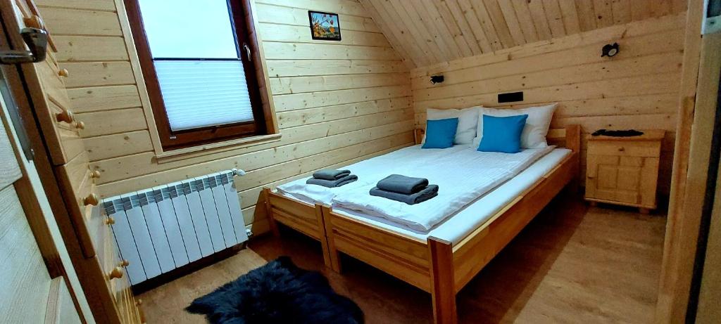 拉普斯尼恩Sołtysie Chaty - Domek z prywatną balią的小木屋内的小卧室配有一张床