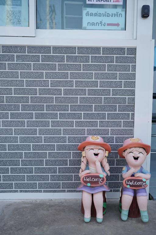 亚兰班萨拜荣格旅馆的两个娃娃站在砖墙前