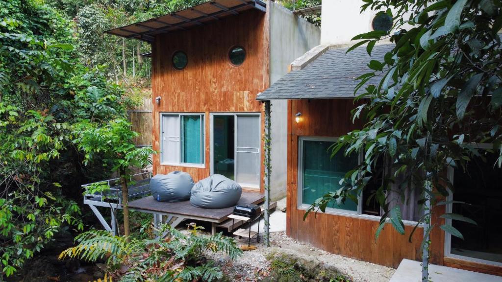 Ban Tha PhaeGreenspace Living的一个小房子,靠长凳上摆着蓝色枕头