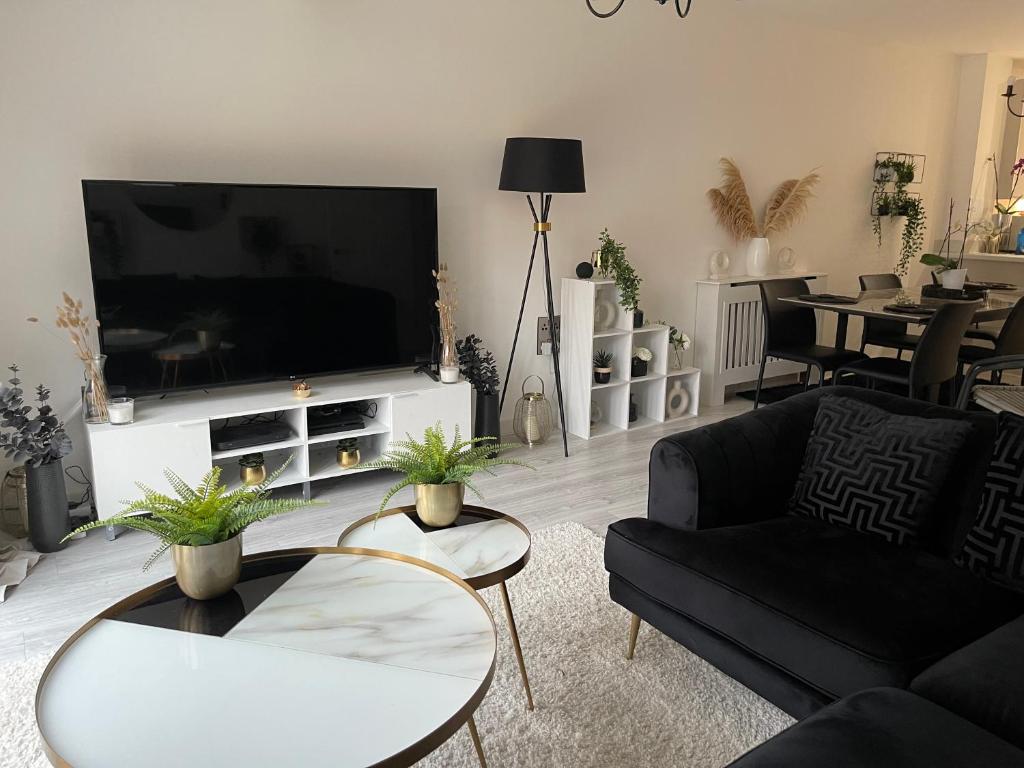 曼彻斯特Cosy Bedrooms的客厅配有电视、沙发和桌子