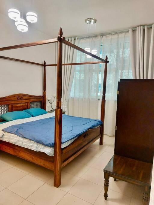 阿吉曼apartment in Ajman for 4 persons near the sea的一间卧室配有一张带蓝色床单的天蓬床