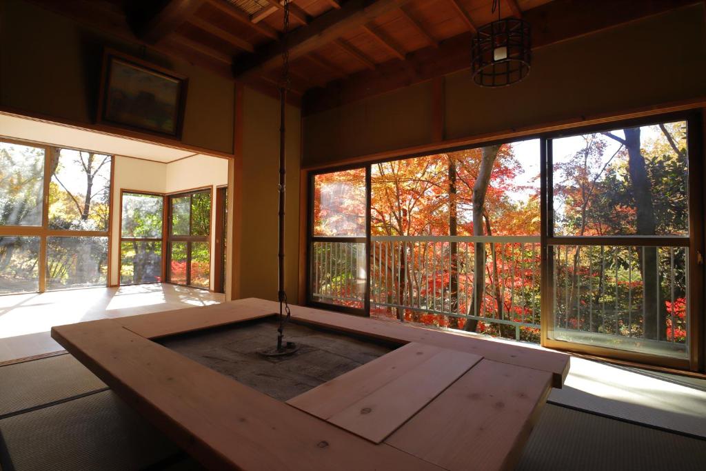 奈良HAT byakugoji, Japanese traditional fireplace　HAT白毫寺　自然豊富な別荘地にある囲炉裏付き一軒家的窗户前设有木桌的房间