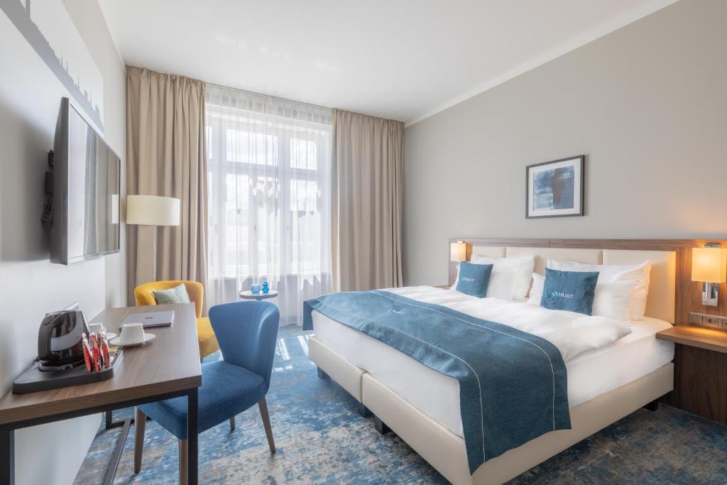 克拉根福Select Hotel Moser Verdino Klagenfurt的配有一张床和一张书桌的酒店客房