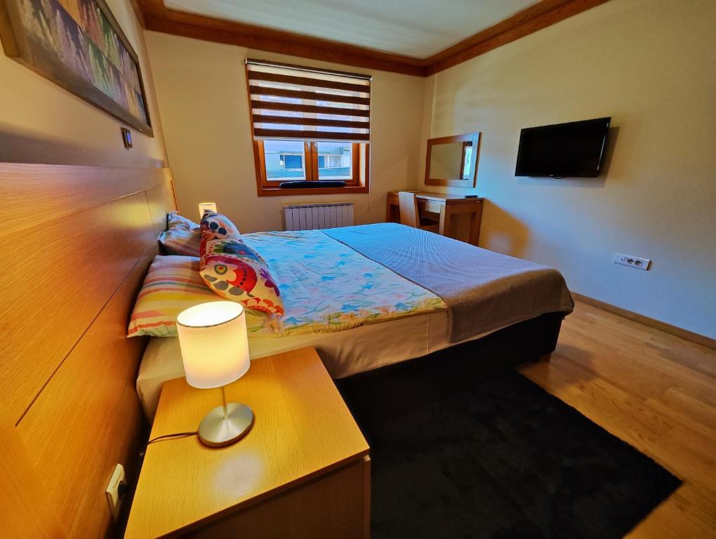 亚霍里纳Vučko Apartment 107 Jahorina的一间卧室配有一张床和一张带台灯的桌子