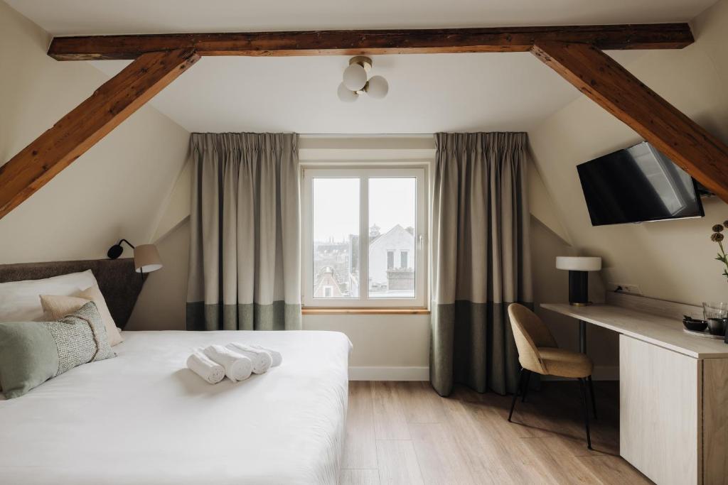 阿姆斯特丹Adam Suites Hotel的酒店客房设有床和窗户。