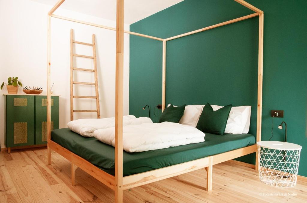 CarriolaForesteria Cà di Nadin的一间卧室配有带梯子的天蓬床