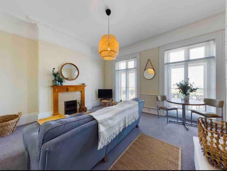 大雅茅斯Spacious apartment with Sea Views on Great Yarmouth Seafront的客厅设有蓝色的沙发和壁炉