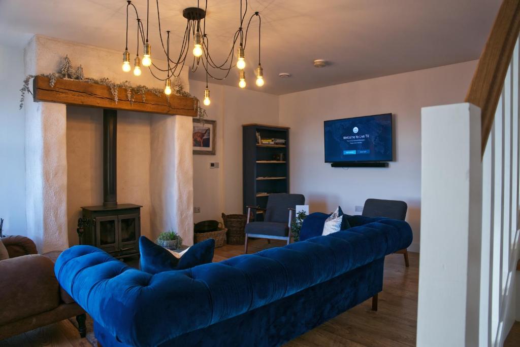 安纳隆Irish Sea Cottage的客厅设有蓝色的沙发和壁炉