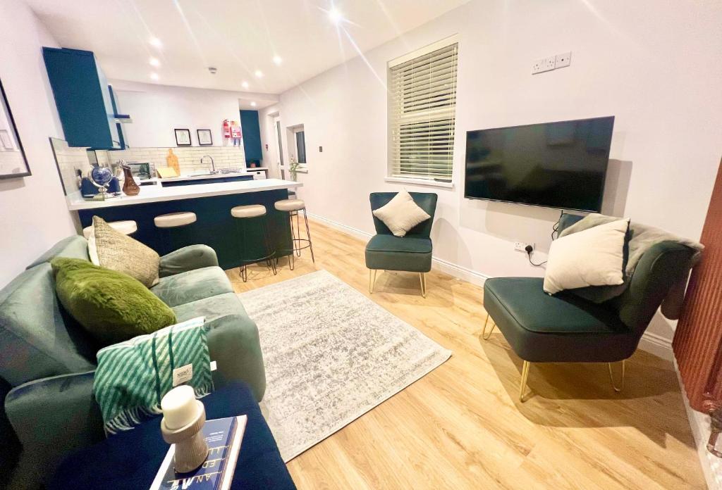 斯旺西Gorgeous Newly Renovated 2 Double Bed Flat的客厅配有沙发、椅子和平面电视。