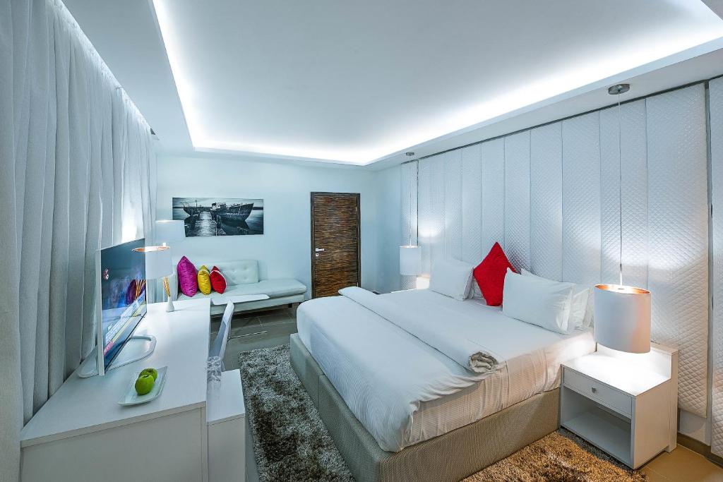 拉各斯Maison Fahrenheit的卧室配有一张白色大床和一张书桌