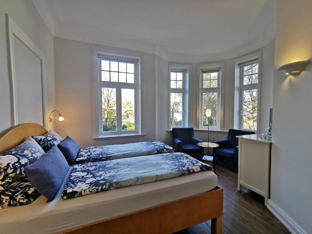 库克斯港黛琪沃吉别墅酒店的一间卧室配有一张床、一把椅子和窗户。